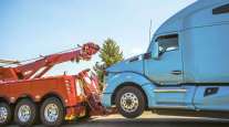 A tow truck hitches on to a tractor.